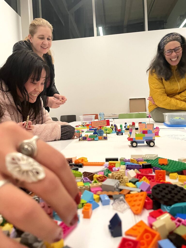 Participants having fun building a desktop walkthrough with LEGO